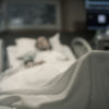 Sick woman lying in hospital bed.