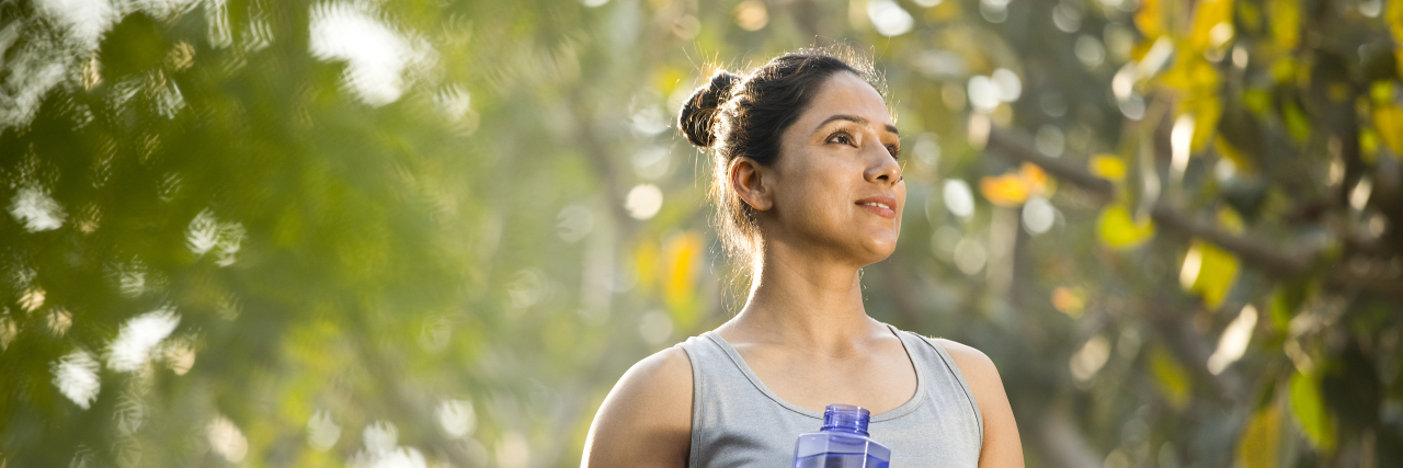 Why Fitness Culture Is Often Toxic to People With Disabilities Woman in sportswear drinking water at park.