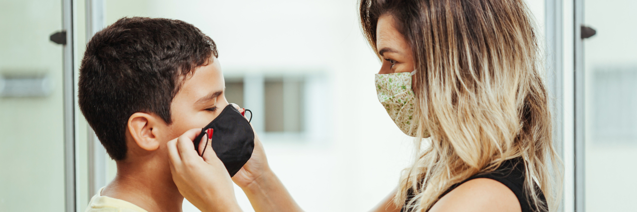 Hey, World: My High-Risk Child Matters in This Pandemic Mother helping son put on a mask.
