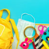 Back to school. Yellow backpack with school supplies, protective medical mask, calculator, scissors.