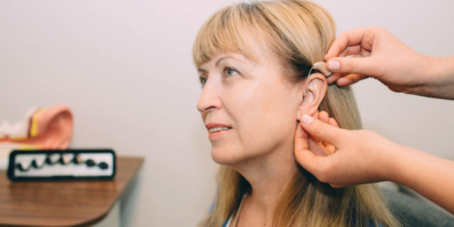 A woman getting her hearing aids adjusted