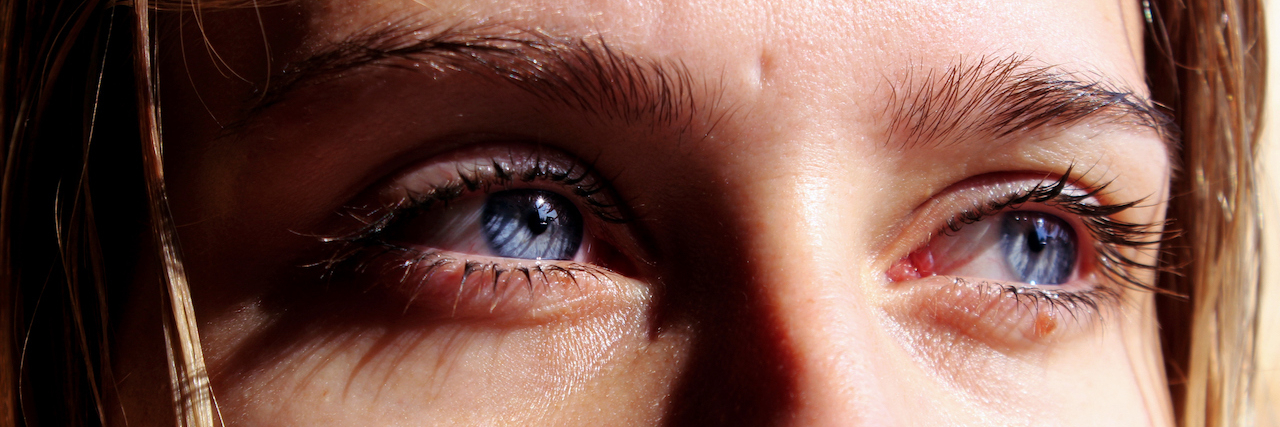 What It's Like to Get EMDR When You Have C-PTSD A close up of a woman's face who has blue eyes an blonde hair