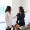 Woman talking to female doctor about endometriosis symptoms.
