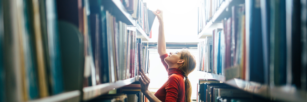How I Reacted When My Fibromyalgia Pain Returned Librarian getting a book from a shelf.