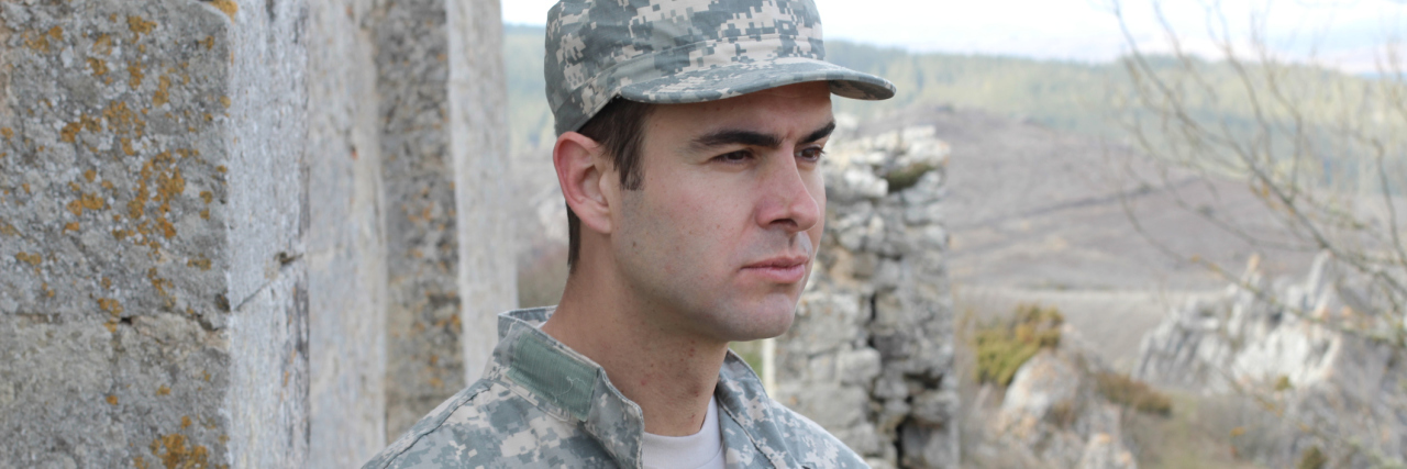 Man in Army uniform looking away thoughtfully