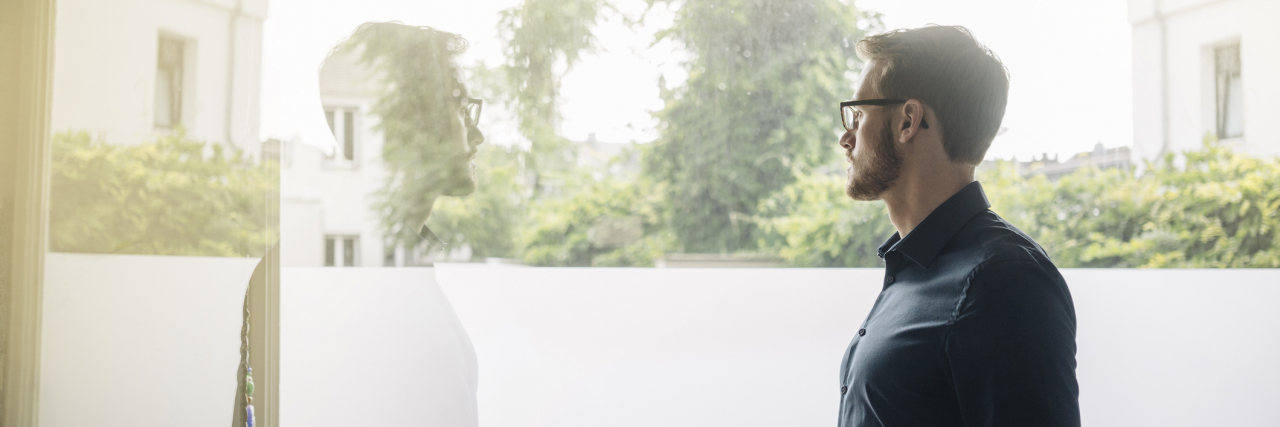 I Miss Being Able to Use Quarantine as an Excuse for Why I'm Single Young man in glasses looking out a window