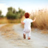Toddler boy running on path.