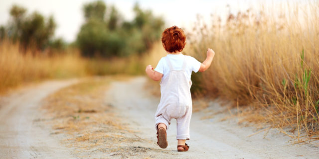 Toddler boy running on path.