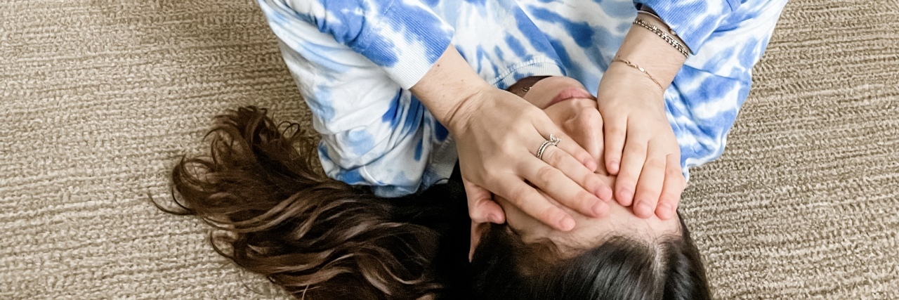 The Support I Need During a Chronic Illness 'Mega-Flare' Natalie laying on the floor in pain.