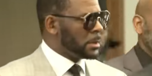 What Trauma Survivors Need to Know About the Upcoming R. Kelly Trial screenshot of R. Kelly wearing sunglasses during period of trial for sexual abuse allegations