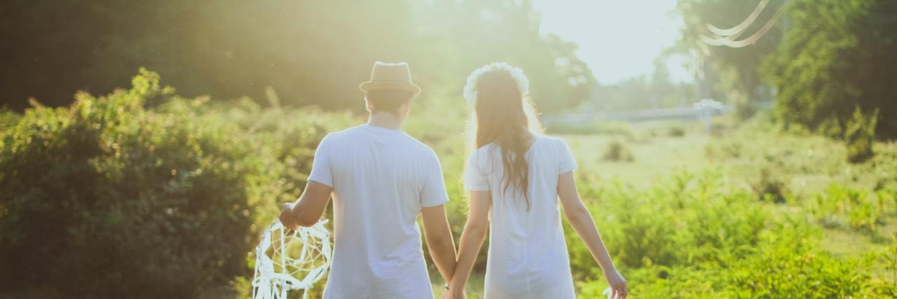 4 'Insider Tips' for People Newly Diagnosed With Multiple Sclerosis Couple walking hand in hand holding dreamcatchers.