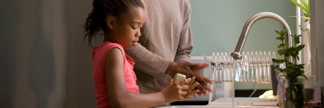 a dad helping his daughter near the kitchen sink