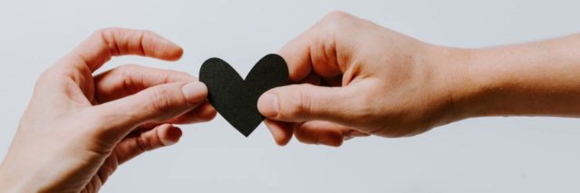 Photo of two hands holding a small heart