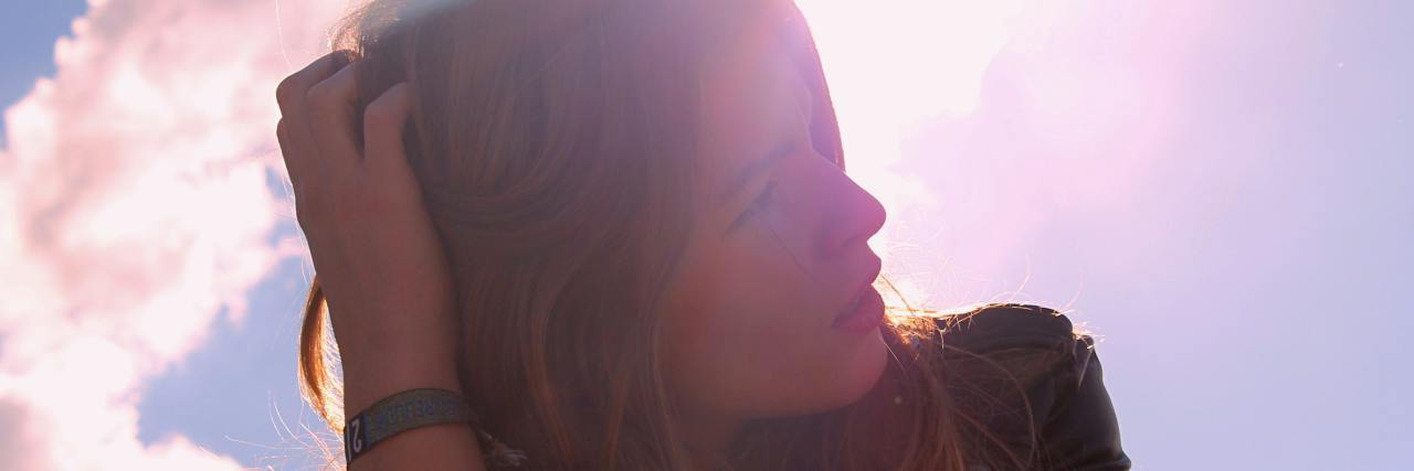 Young white woman with blonde hair looking up at the sky