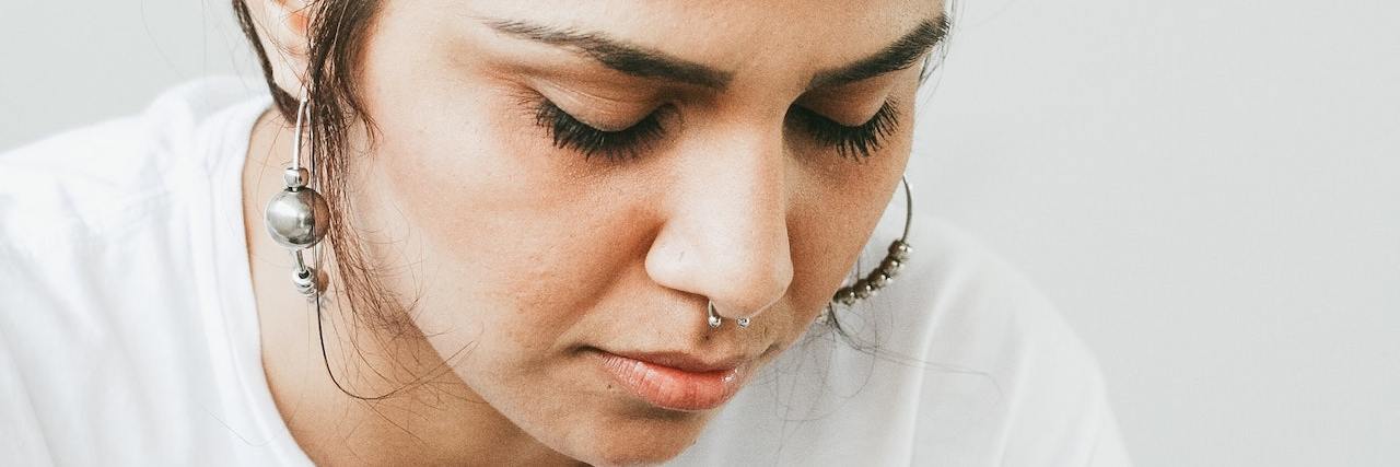 My ADHD Is Still Valid Even If I'm Not on Medication A woman looking down