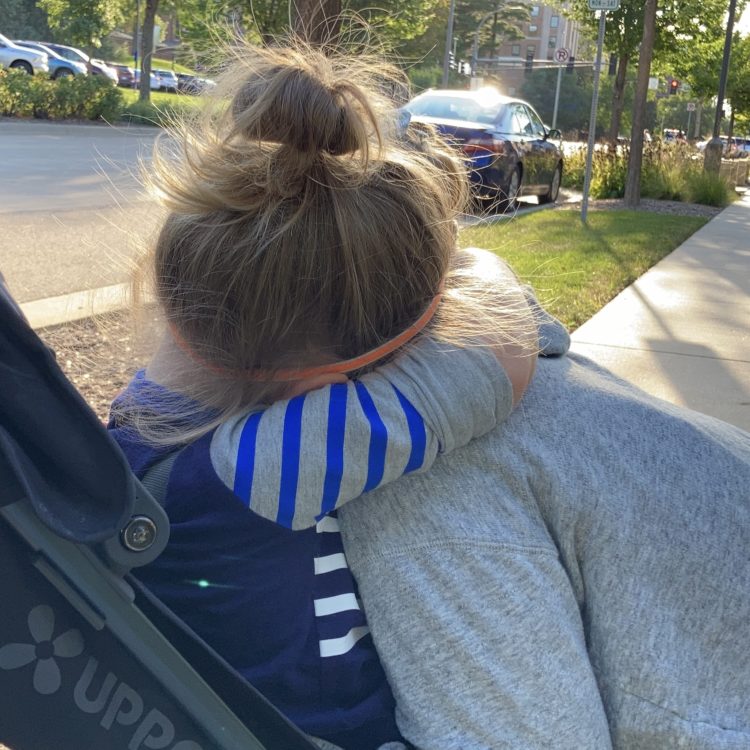 Person hugging child in stroller