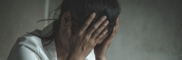 Stressed woman holding her head in her hands.
