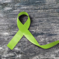 Green ribbon for mitochondrial disease awareness.