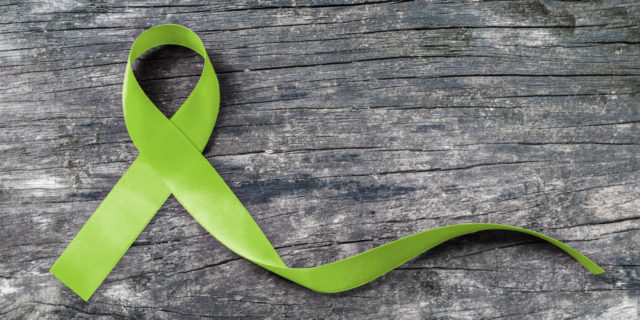 Green ribbon for mitochondrial disease awareness.