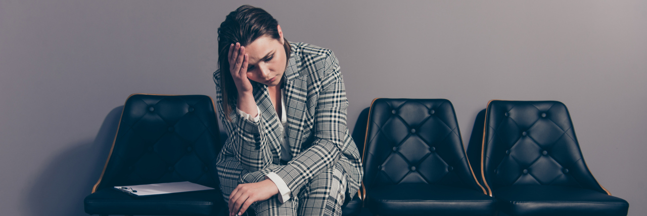 When a Micromanaging Boss Destroys Your Mental Health Businesswoman sitting in a chair by herself, stressed