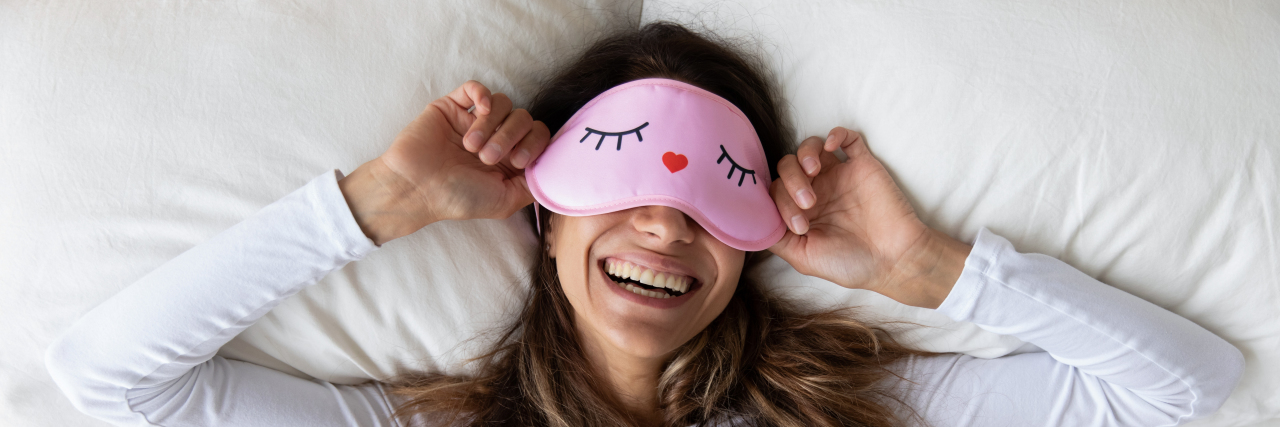 What My 'Better' Days With Fibromyalgia Are Like Woman waking up wearing an eye mask.