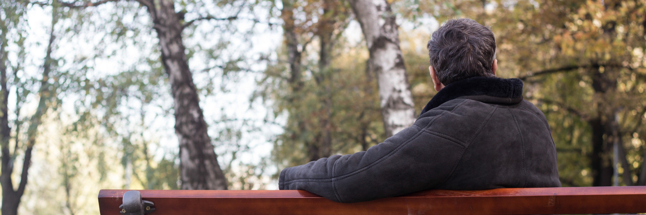 What Tips and Tricks Have and Haven't Worked for Rheumatoid Arthritis Man sitting on a park bench.