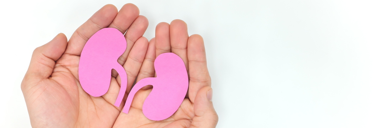 What Patients Should Know About Living With Primary Hyperoxaluria Type 1 Hands holding paper cutout of kidneys.