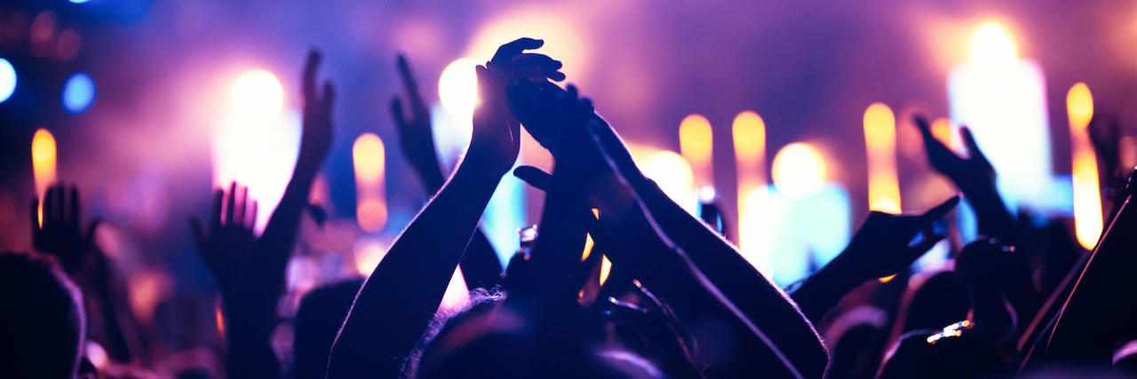 Attending a Festival With My Ileostomy Bag Cheering crowd with hands in air at music festival