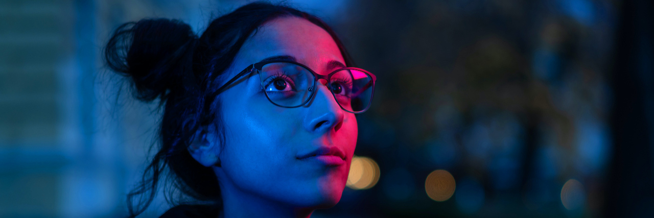 The Significant Link Between Addiction and Schizophrenia Night portrait of woman with glasses looking at neon lights