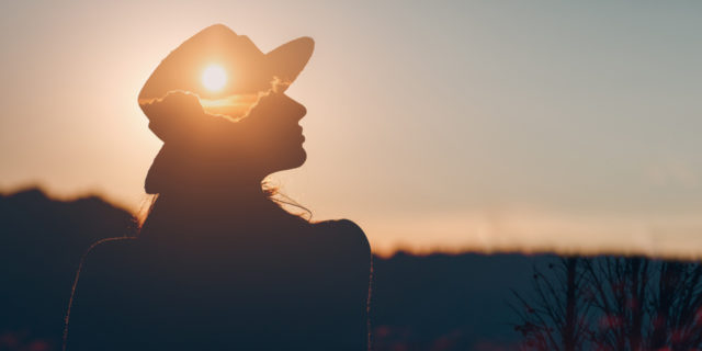 silhouette of a woman staring at the sunset