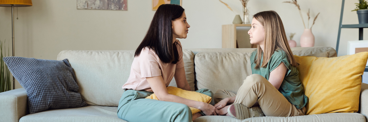 What I Would Tell My Younger Self Struggling With Depression A woman sitting on the couch talking to her younger daughter