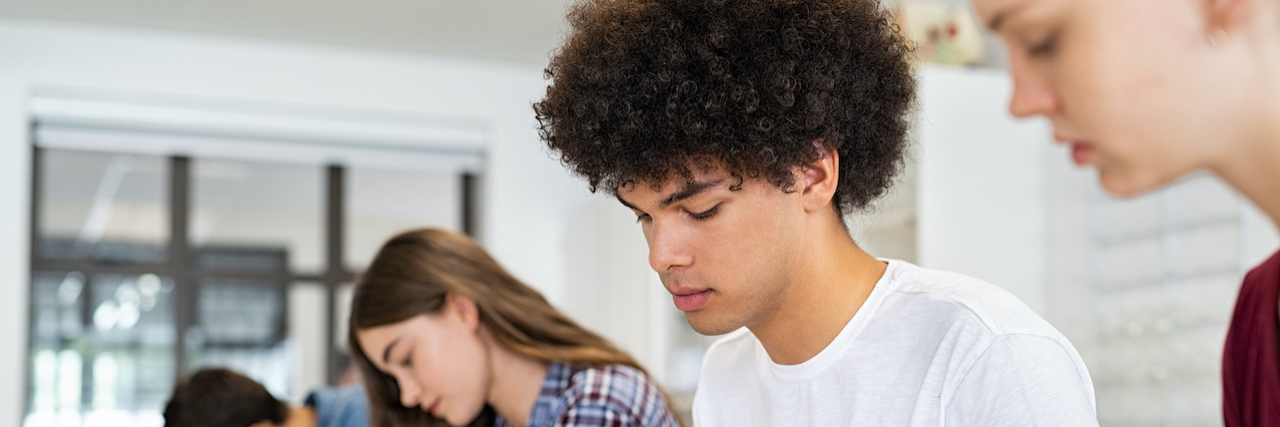 Schools Are Recognizing Students' Need for 'Mental Health Days' Diverse group of high school students writing in workbooks