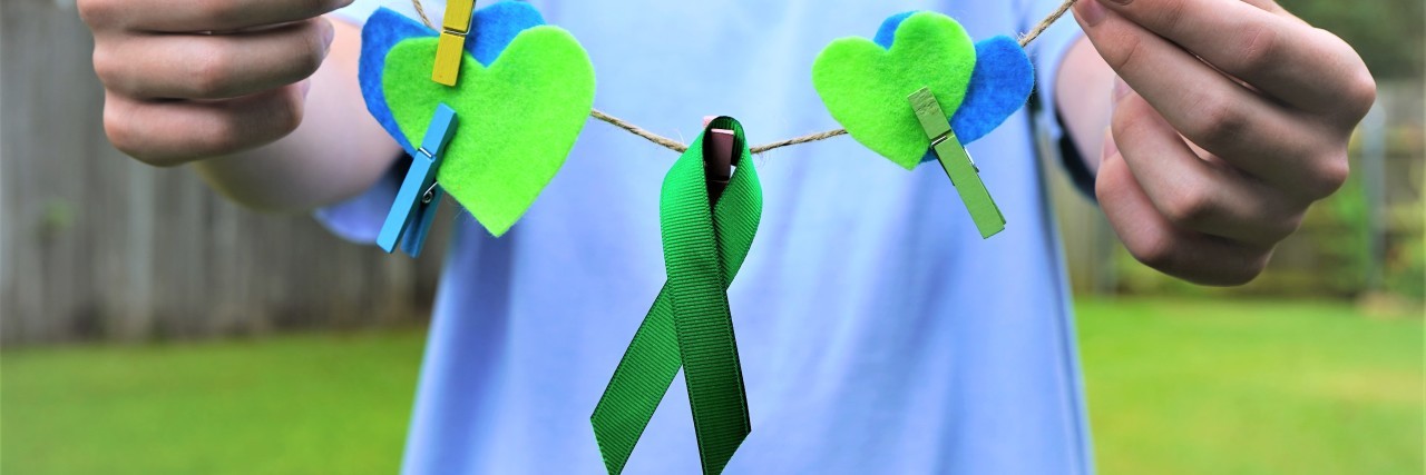 Taking Care of My Physical and Mental Health With Cerebral Palsy Green ribbon, hearts, pinned to clothesline.