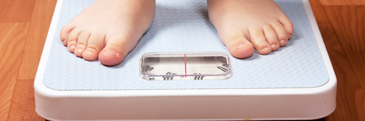 How Fatphobia and the Focus on 'Childhood Obesity' Affected Me Closeup view of kids feet on scale on the floor