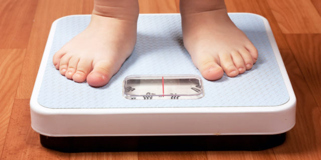 How Fatphobia and the Focus on 'Childhood Obesity' Affected Me Closeup view of kids feet on scale on the floor