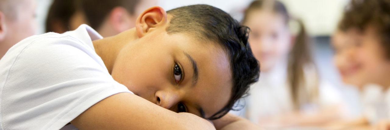 Schools Need to Stop Labeling Our Children 'Sped Kids' Little boy at school who looks distant and upset.