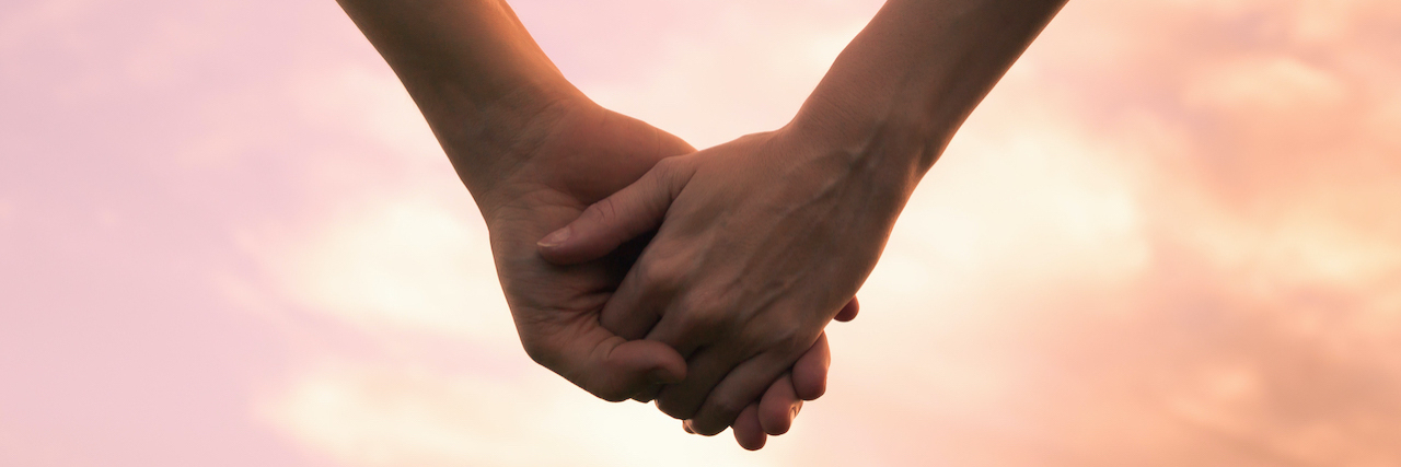 Fighting to Find Treatment and Cure for Crohn's Disease Couple holding hands against the sunset.