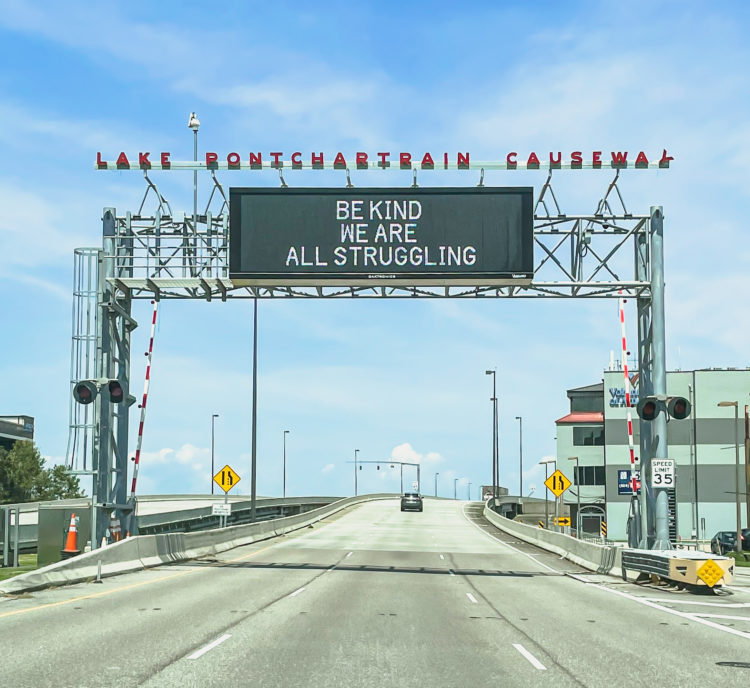 Photo of highway sign saying "Be kind, we are all struggling"