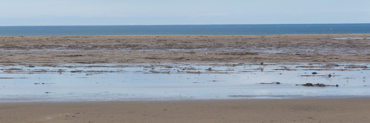 What Self-Care Really Involves sand and surf at a beach