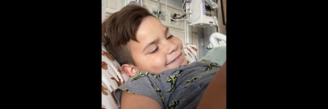 a boy smiling in his hospital bed
