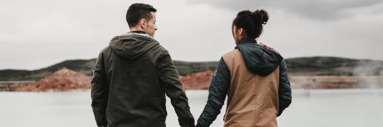 How My Husband and I Support Each Other With Depression man and woman holding hands, looking at each other smiling, overlooking a lake