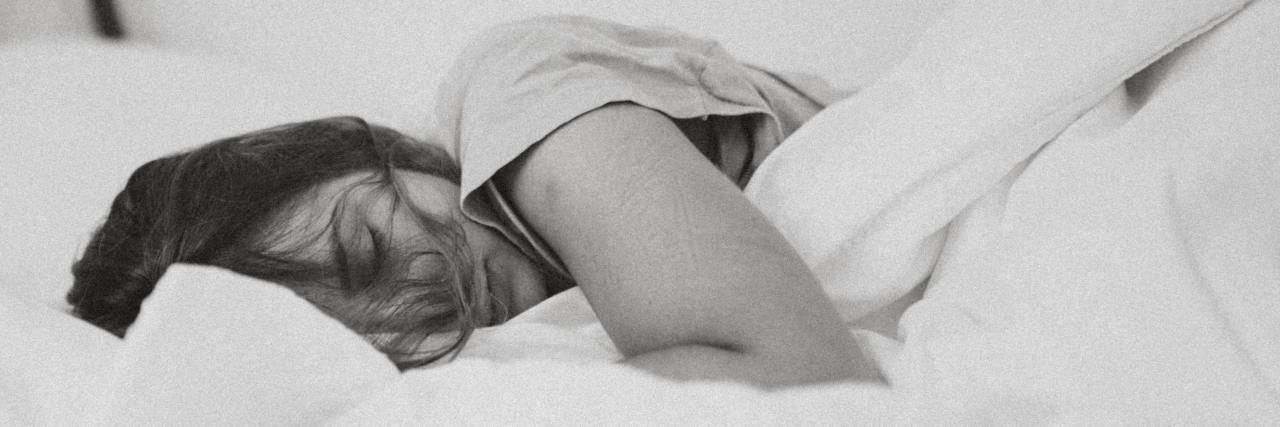 Read This If You're Tired of Fighting Depression, Want to Just Exist black and white photo of a woman lying in bed asleep