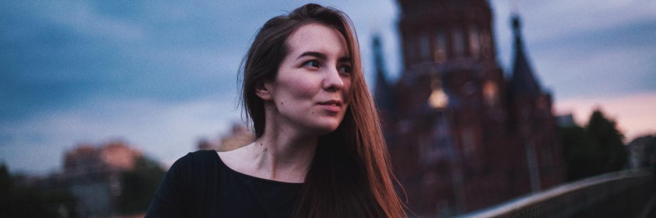 My Positive Experience Admitting Myself to a Psychiatric Hospital A young woman standing outside in the evening looking away