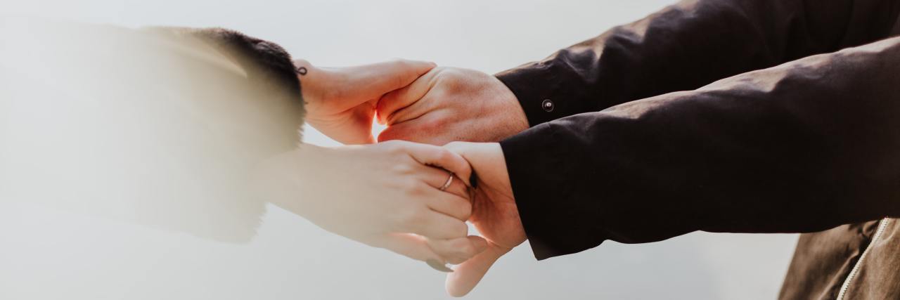 To the Person With Schizophrenia Who Doesn't Feel Loved Man and woman with their arms outstretched, holding hands