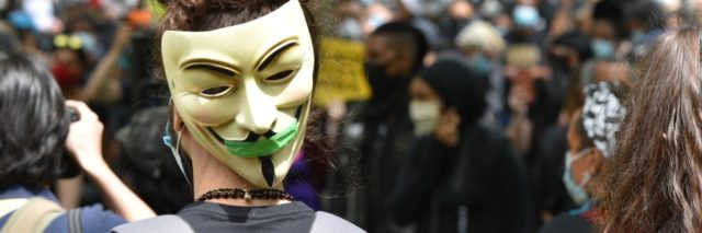 photo of a protest and someone wearing a V mask