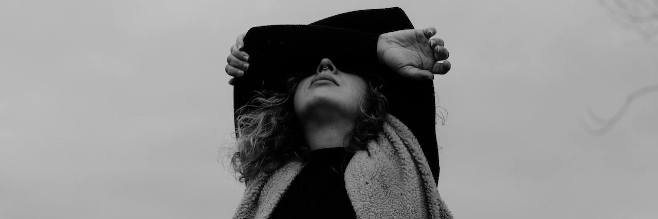 It Took Me 8 Years to Get the Mental Health Help I Needed A woman covering her eyes with her arms