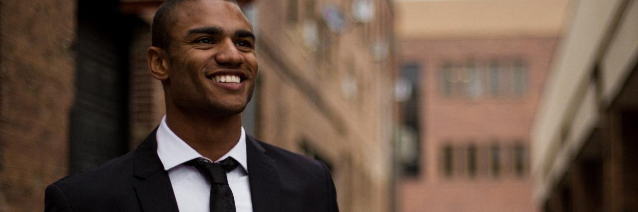 Being Cleared to Work Again After a Manic Episode With Bipolar photo of a man in a city street smiling