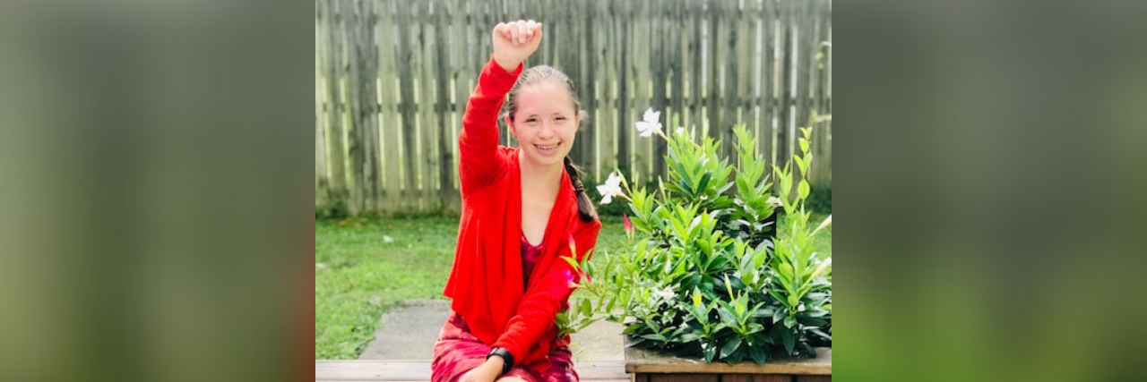 When Your Young Adult With Down Syndrome Is Diagnosed With Autism Yassy raising her fist in victory.