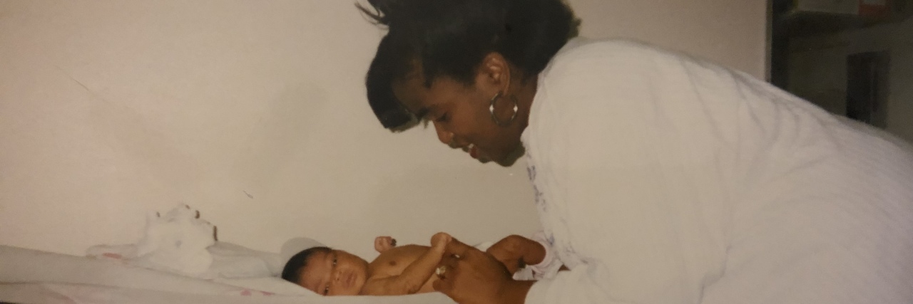 Black mother smiling at infant daughter