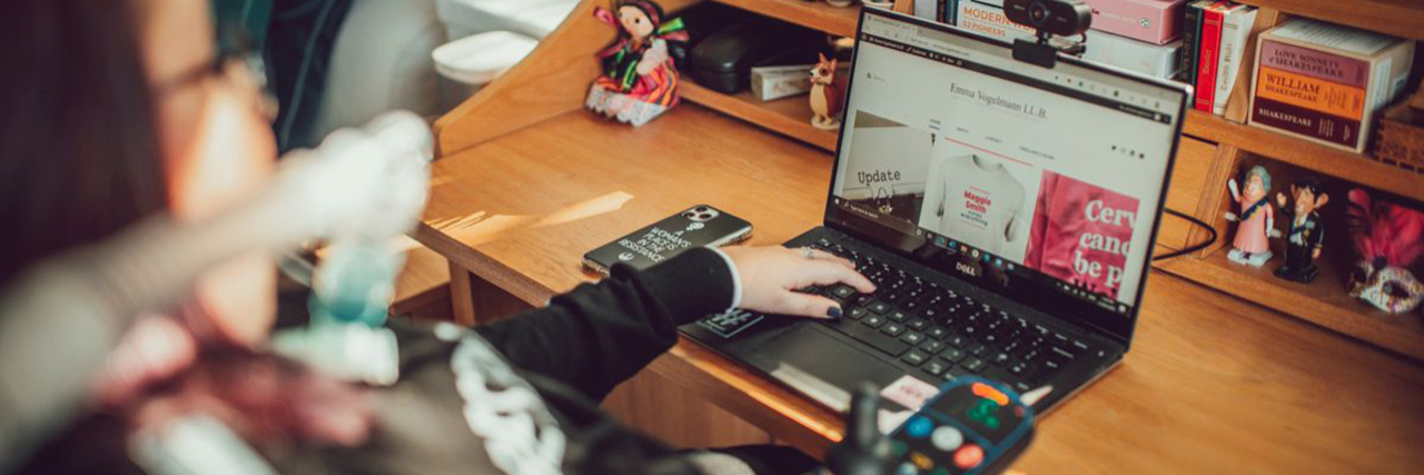 Overcoming Internalized Ableism to Embrace Assistive Technology Emma using her laptop.